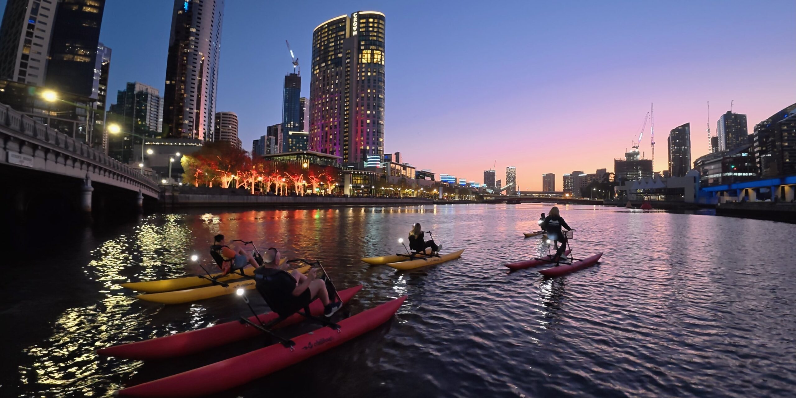 Group waterbiking on the Yarra River in Melbourne at twilight